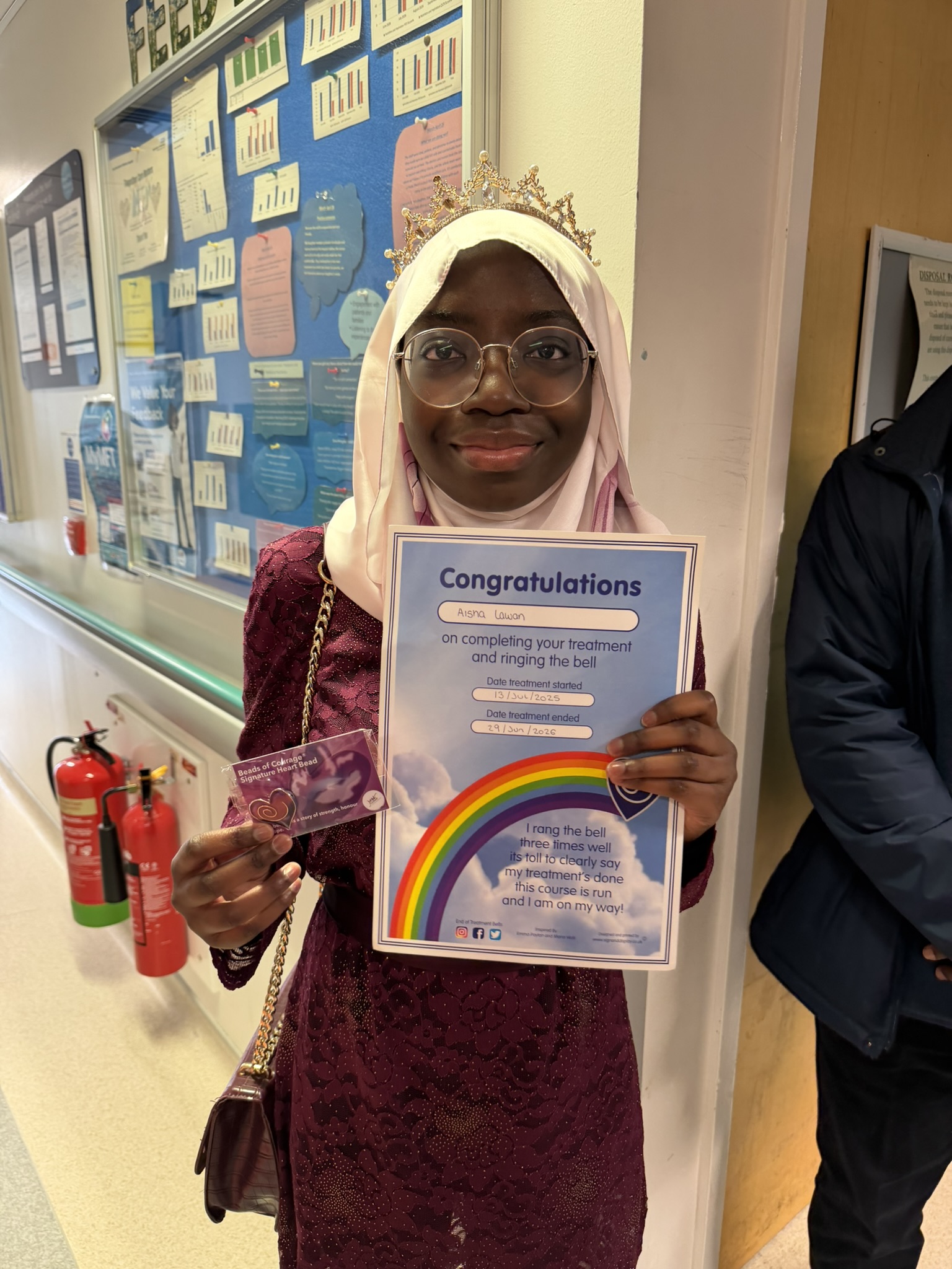 Young woman holding certificate and badge.
