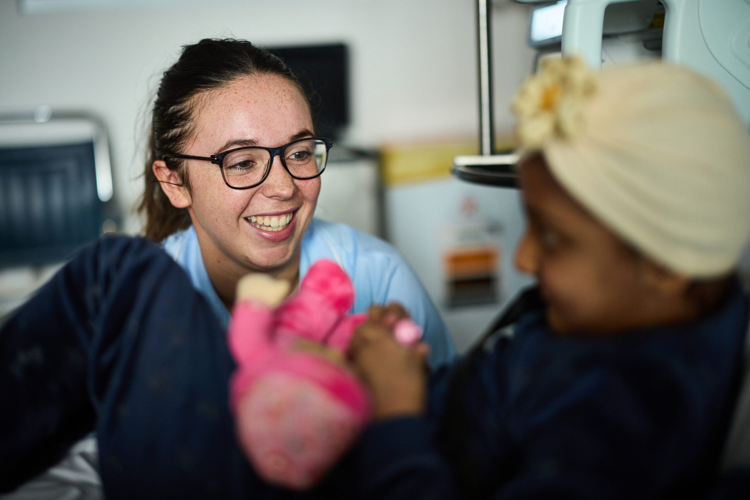 Nurse smiling at a child in a hospital bed